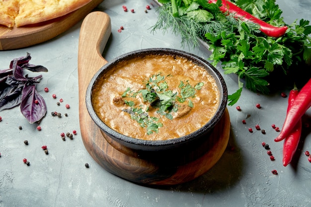 Georgian cuisine dish - green kharcho with beef, rice and plum sauce