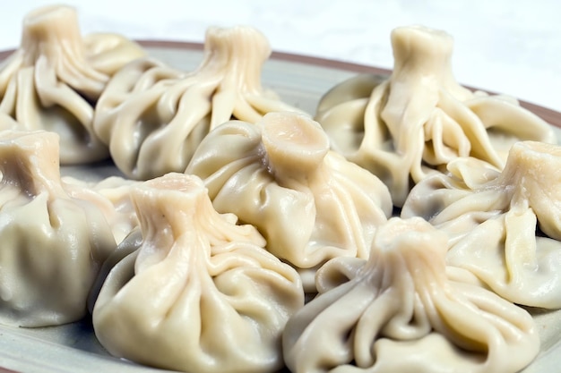 Georgian dumplings Khinkali with meat on white plate.