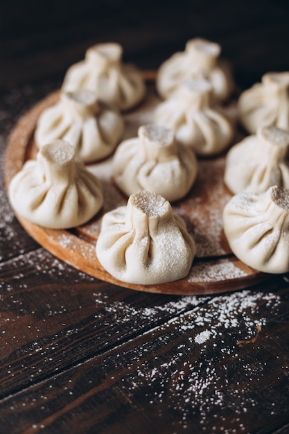 Georgian homemade dumpling or khinkali on cutting wooden board.