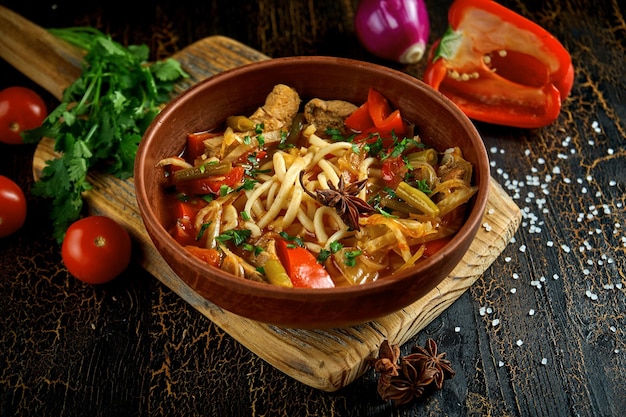 Georgian Laghman soup with ribs and noodles in a clay pot Dark background