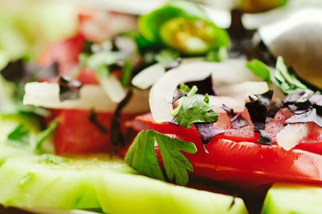 Photo georgian vegetable salad with onion, basil, tomato, parsley and pepper