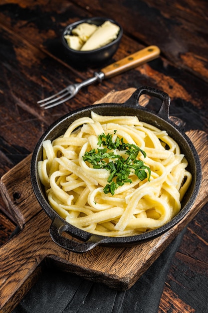 German Spaetzle egg Noodles with Butter and Parsley in a skillet Wooden background Top view