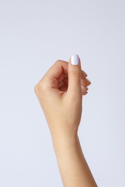 Gesture and sign, female hand holds something on light