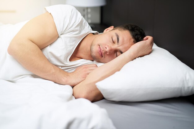 Getting all the sleep his body needs Cropped shot of a handsome young man asleep in his bed0