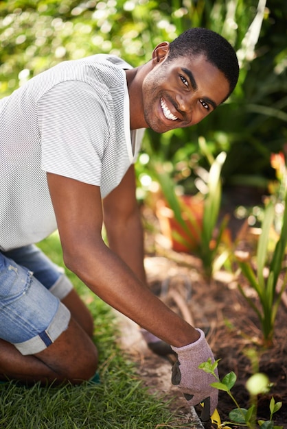 Getting down in the dirt Portrait of a handsome young black man gardening