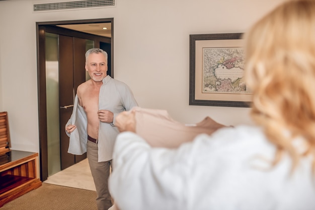 Getting dressed. A man a nd a woman getting dressed in a hotel room