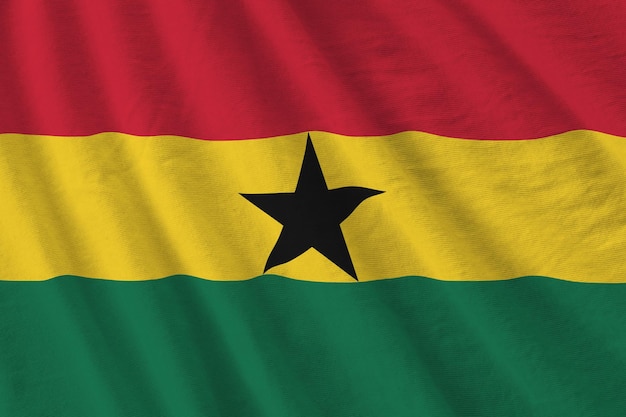 Ghana flag with big folds waving close up under the studio light indoors The official symbols and colors in banner