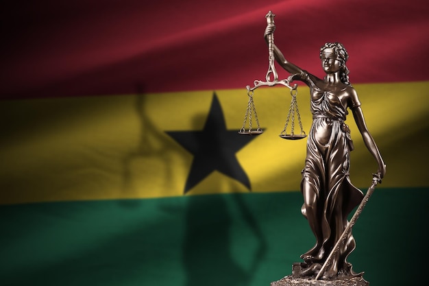 Ghana flag with statue of lady justice and judicial scales in dark room Concept of judgement and punishment