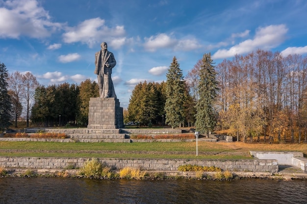 Giant Lenin monument surrounded by trees at bank of river near waterpower plant Dubna Russia