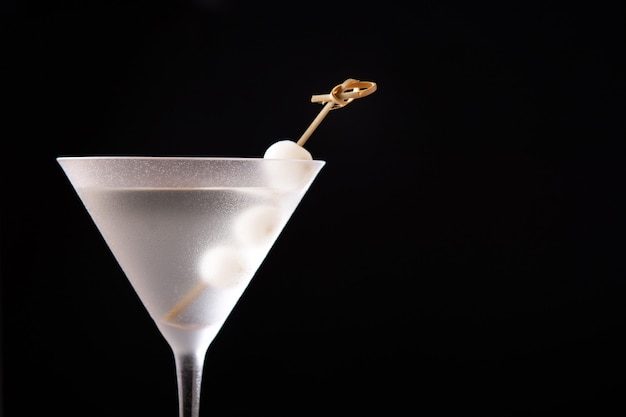 Gibson martini cocktail with onions on black background