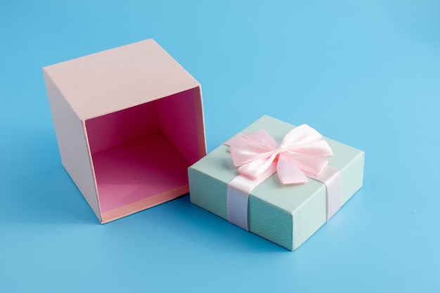 Gift in a beautiful package box with gifts attributes festive mood gift on a blue background