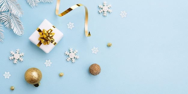 Gift bow with christmas golden decorations on blue background