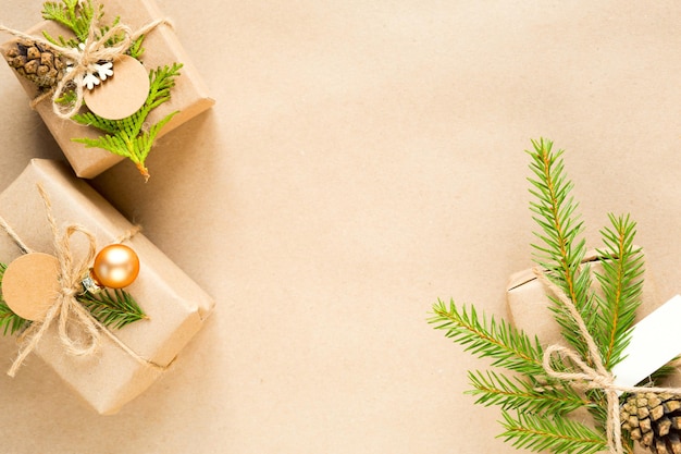 Gift box for Christmas and new year in eco-friendly materials: kraft paper, live fir branches, cones, twine. Tags with mock up, natural decor, hand made, DIY. Flatly, background, frame, Minimalism