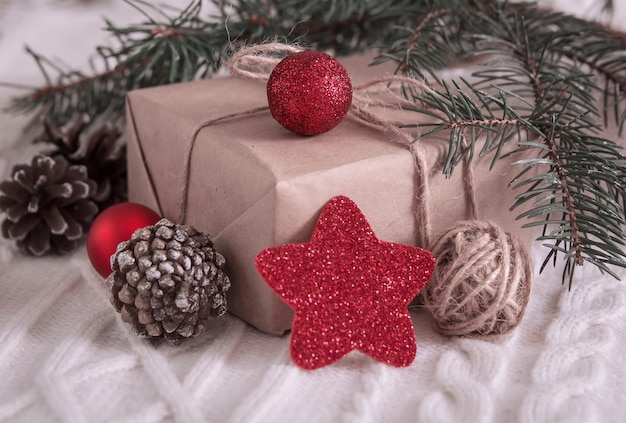 Gift box and christmas tree branch and decorations on white