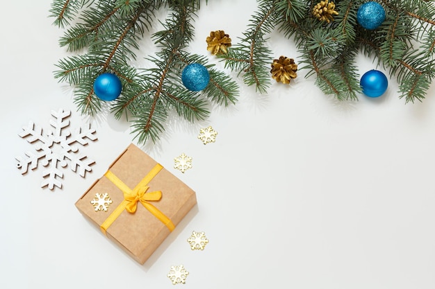 Gift box fir tree branches with balls on gray background