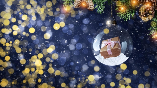 Gift box in glass christmas bauble with fir branch on winter snowy background