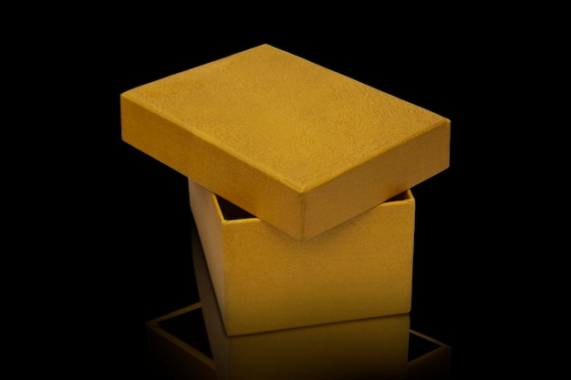 Gift box in gold color on a black background The concept of gifts holidays