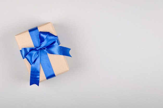 Gift box on gray background composition, present with ribbon and bow.