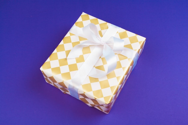 Gift box on purple background top view