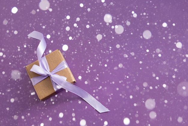 Gift box on purple textured background.