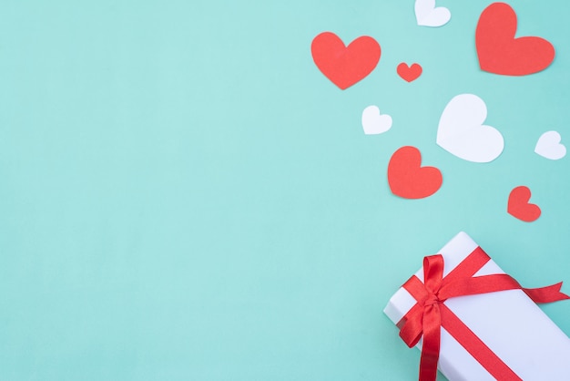 Gift box, red and white hearts on blue pastel background. Valentine's day or wedding ceremony concept