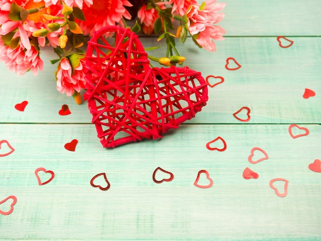 Gift box and red wicker heart on a blue wooden