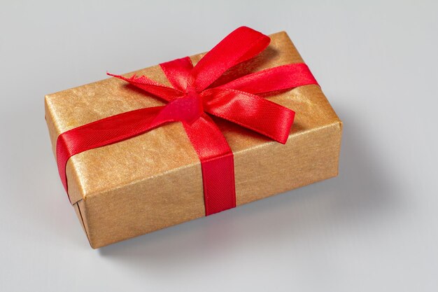 Gift box tied with a red ribbon on the gray background Top view Greeting card concept