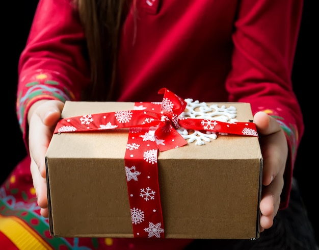 Gift box tied with a red ribbon in the hands