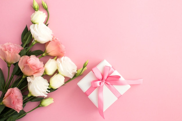 Gift box, white and pink flowers on the pink  background with  copy space