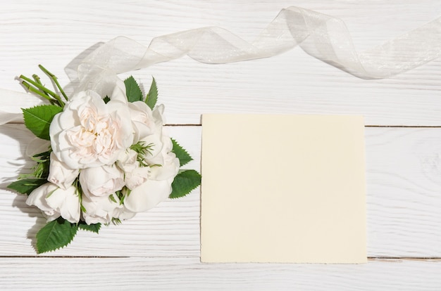 Gift box and white roses with an empty card