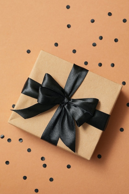 Gift box with black bow on craft paper