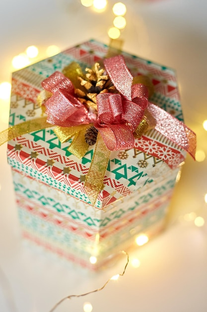 Gift box with a bow on the background of Christmas bokeh