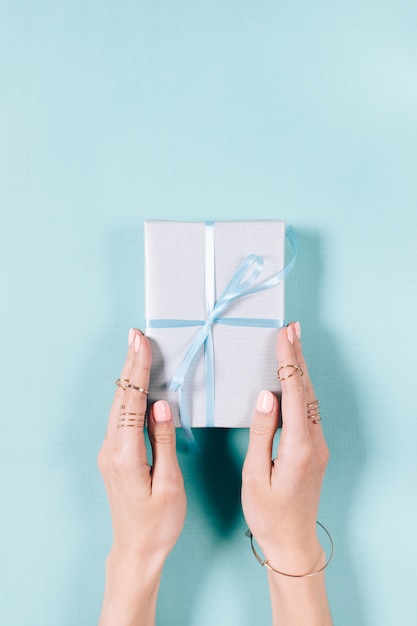 Gift box with bow in female hands