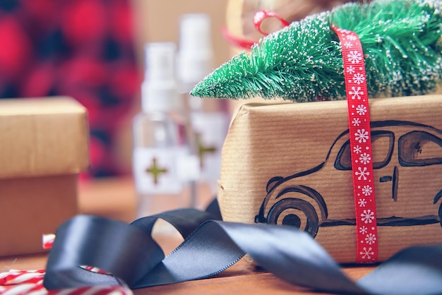 Gift box with car and christmas tree on roof christmas decorations and antiseptics on background lol...