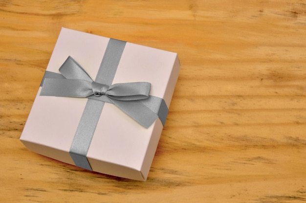 gift box with gray bow on wooden table