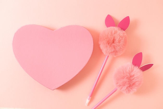 Gift box with a heart and a bunny handle on a naturally beige background