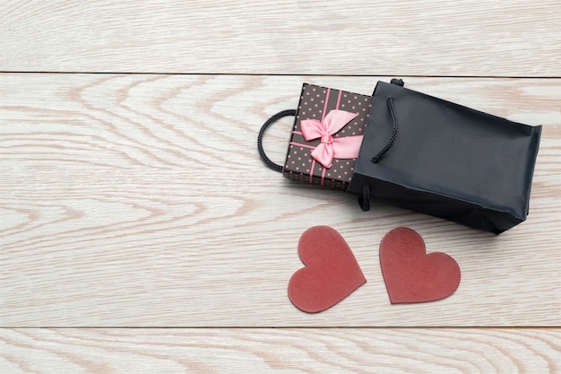 Gift box with and heart decoration on wooden background for Valentines day birthday womens day