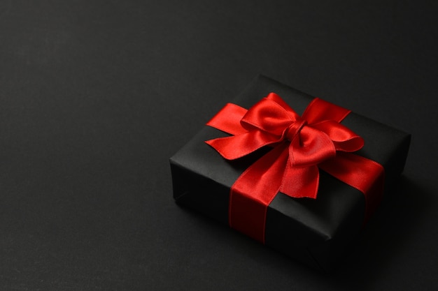 Gift box with red bow on black 