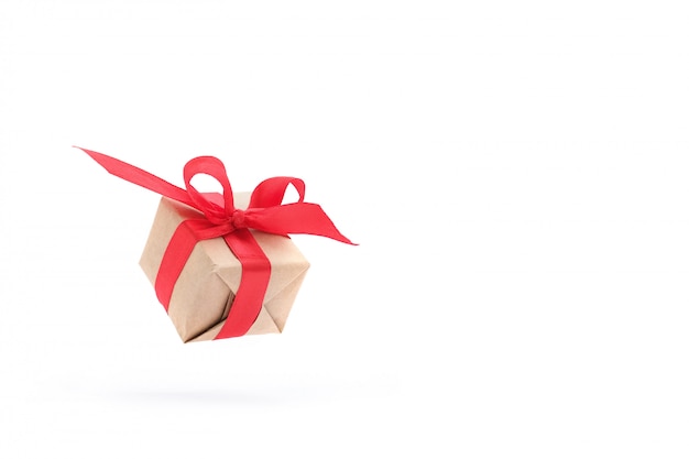 Gift box with red ribbon isolated in air on white.