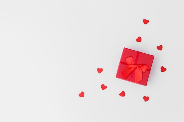 Gift box with small hearts on table 