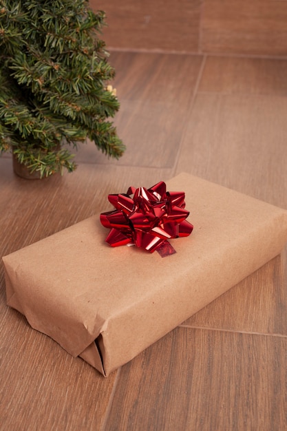 gift box wrapped in kraft paper and red bow Christmas concept