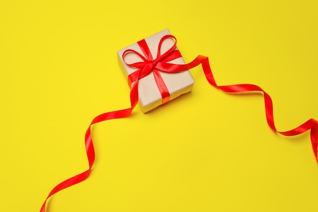 Gift in a box on a yellow background, a composition for Mother's Day.