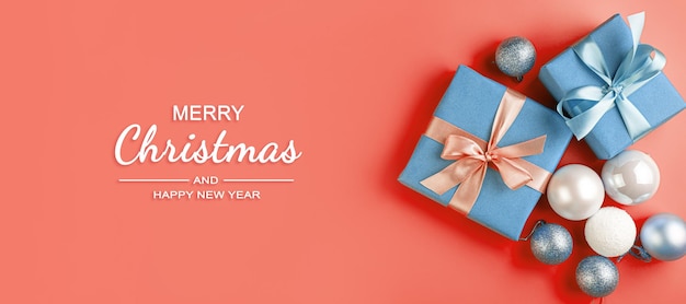 Gift boxes and Christmas decorations on a coral background Merry Christmas and Happy New Year