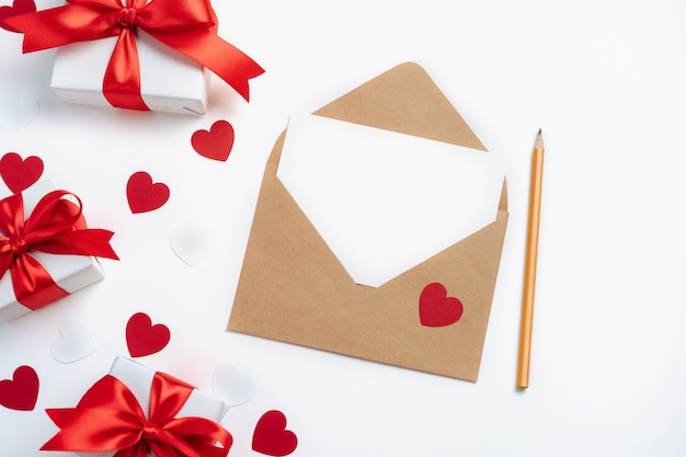 Gift boxes envelope with blank card and red hearts on white