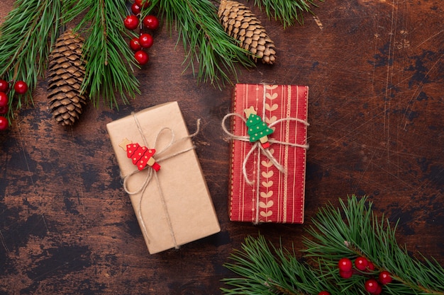 Gift boxes and fir tree branches on wooden background. Christmas greeting card. Top view. copyspace