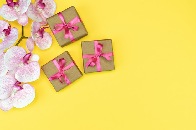 Gift  boxes and orchid flower on yellow background