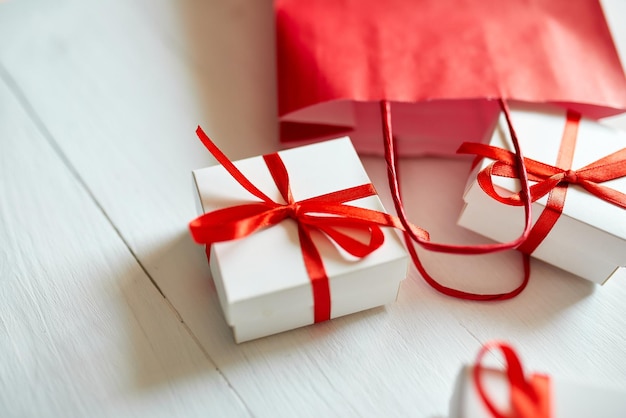 Gift boxes out from red paper bag on white background