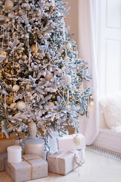 Gift boxes present near the decorated New Years tree. Christmas background. Soft selective focus.