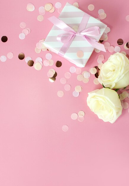 Gift boxes and rose flowers on pink background Happy Valentines day Mothers day birthday concept Romantic flat lay composition