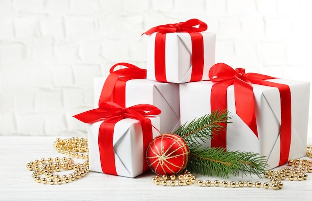 Gift boxes with Christmas tree branch and decor on brick wall background